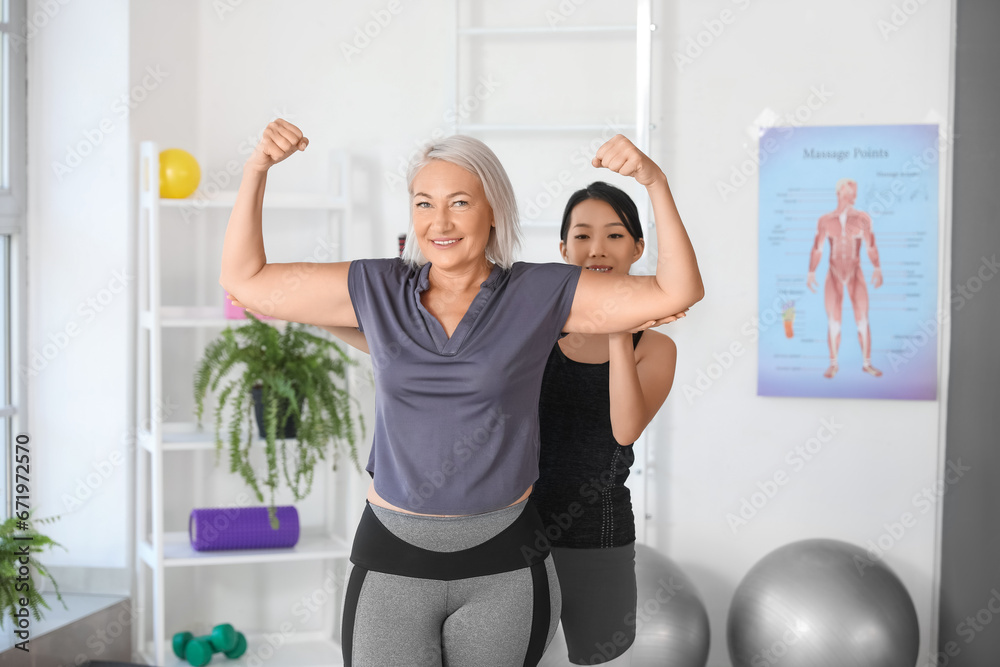 Mature woman training with therapist in rehabilitation center