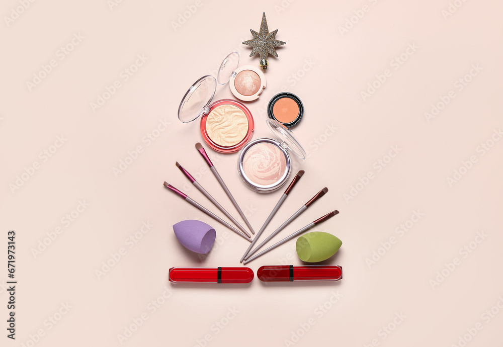 Christmas tree made of makeup products and decor on beige background