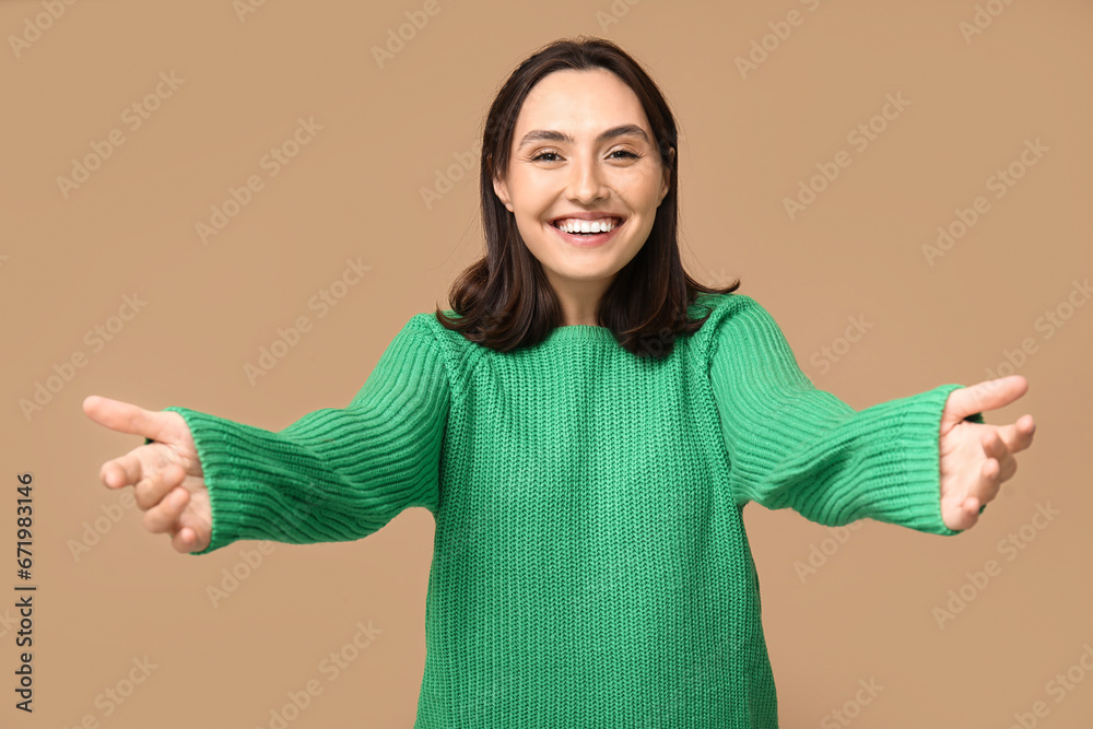 Young woman opening arms for hug on brown background