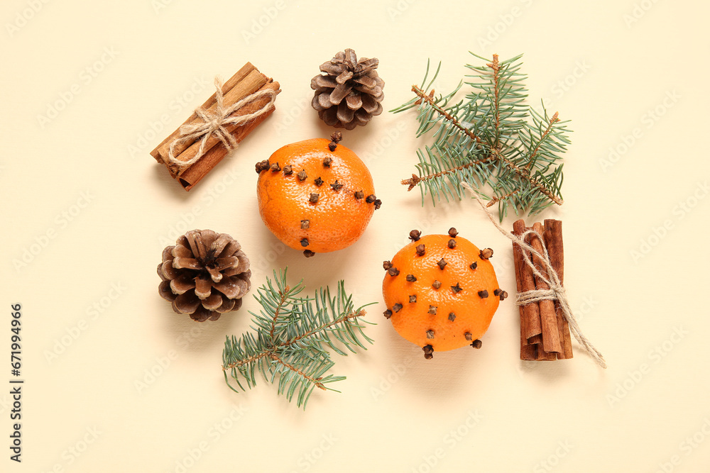 Pomander balls with Christmas tree branches, cones and cinnamon on yellow background