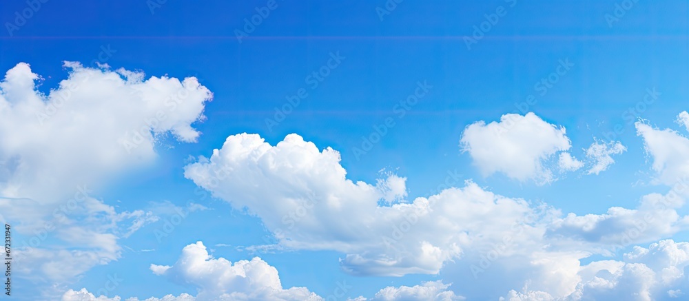 Background of the sky that is blue adorned with small clusters of clouds