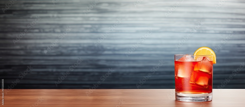 A refreshing mixed drink sits on a gray table in a caf