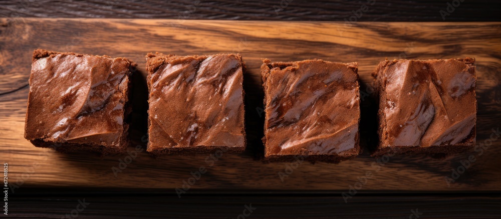 Close up and top view of wooden table with square chocolate brownie pieces