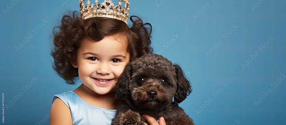 Studio portrait over blue background featuring a lovable princess a charming boy and their regal poodle a true representation of love friendship and family