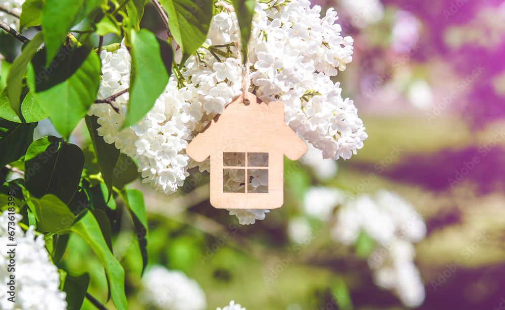 The symbol of the house among the branches of the white lilac 