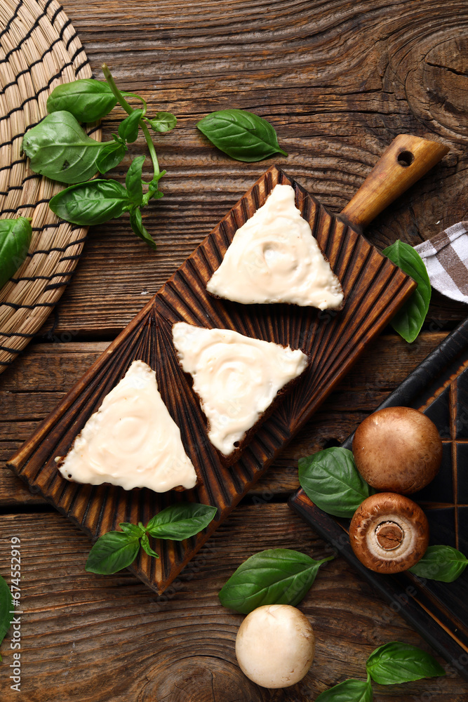 Board of tasty sandwiches with cream cheese on wooden background