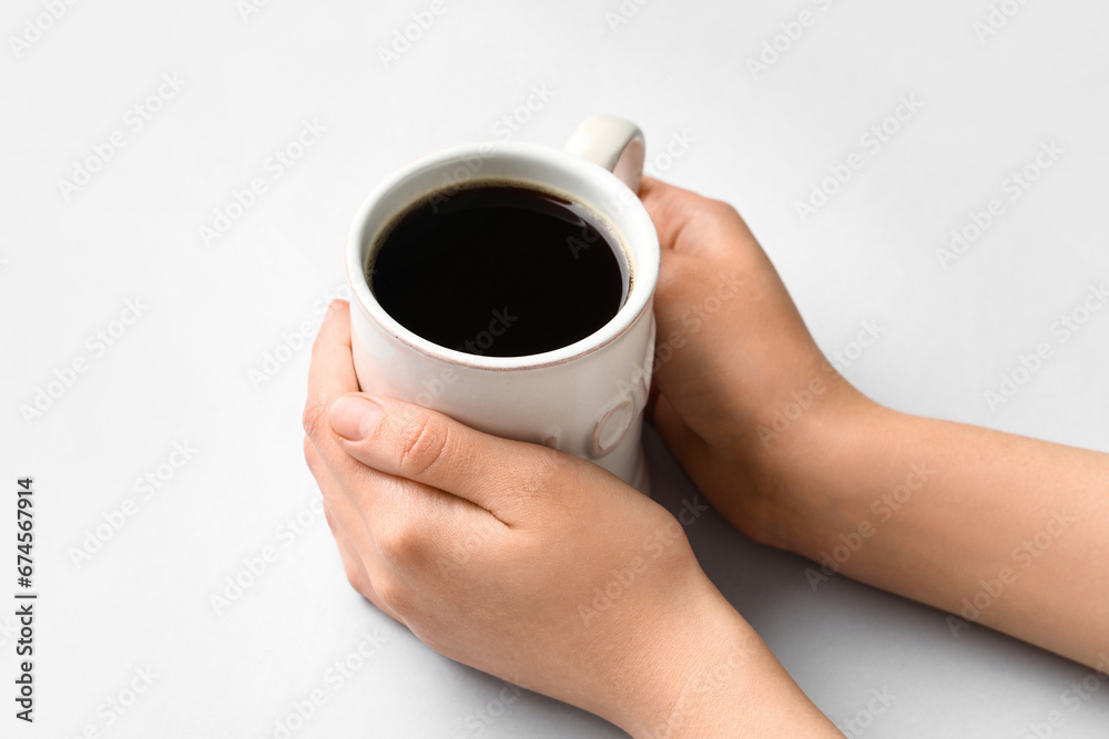 Woman holding cup of hot coffee on white background