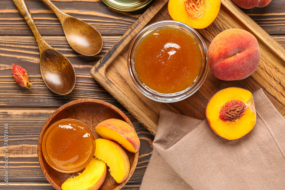 Composition with jar of sweet peach jam and fresh fruits on wooden background, closeup