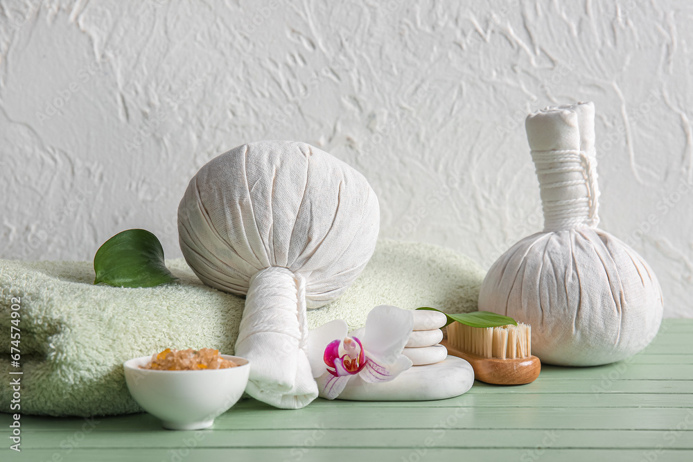 Set of spa accessories on color wooden table against light background