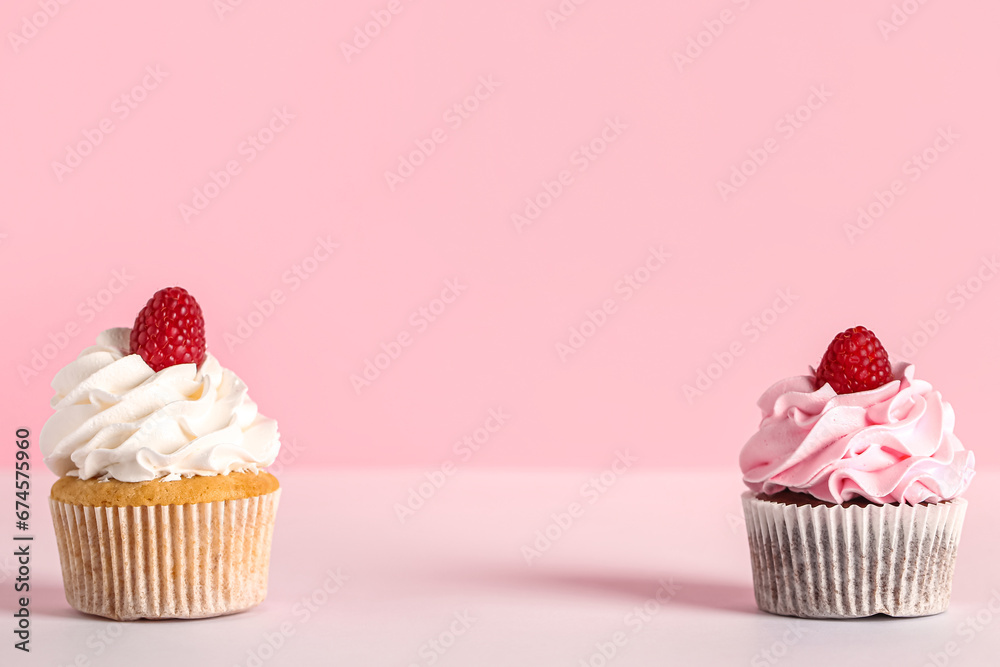 Tasty raspberry cupcakes on pink background