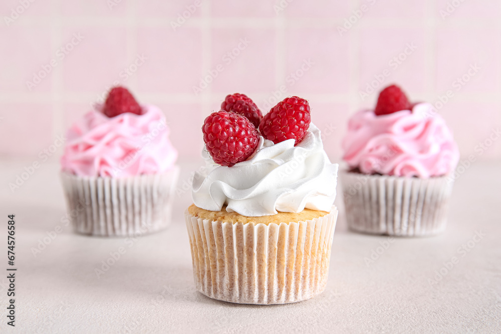 Tasty raspberry cupcakes on table