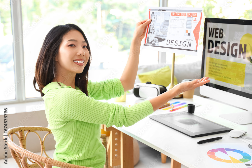 Asian interior designer working with plan at table in office