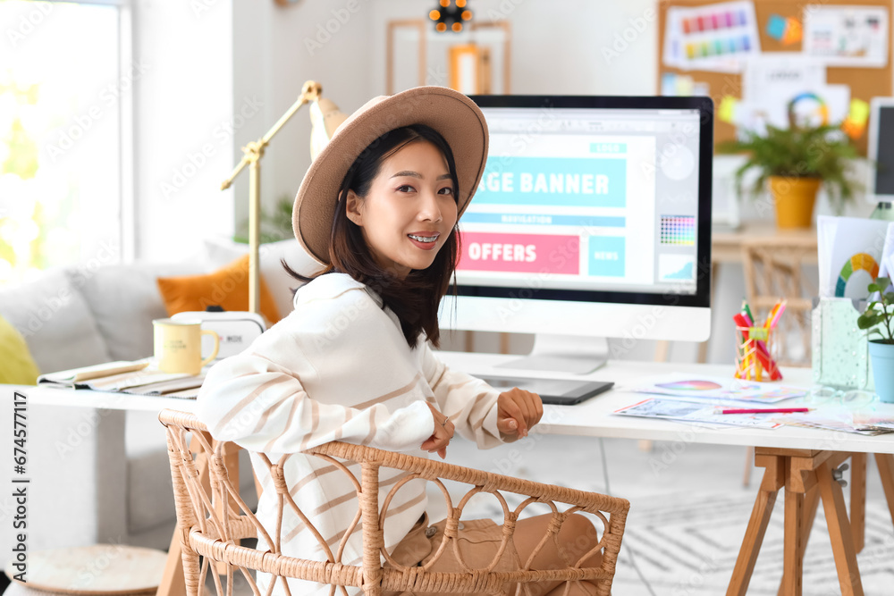 Asian interior designer sitting at table in office