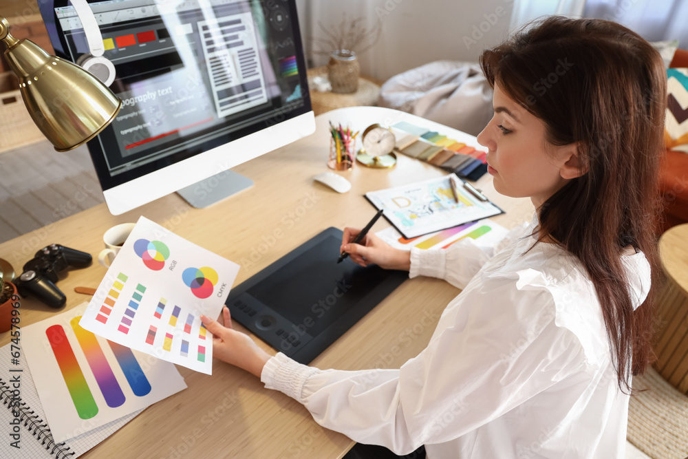 Female interior designer working with graphic tablet at table in office