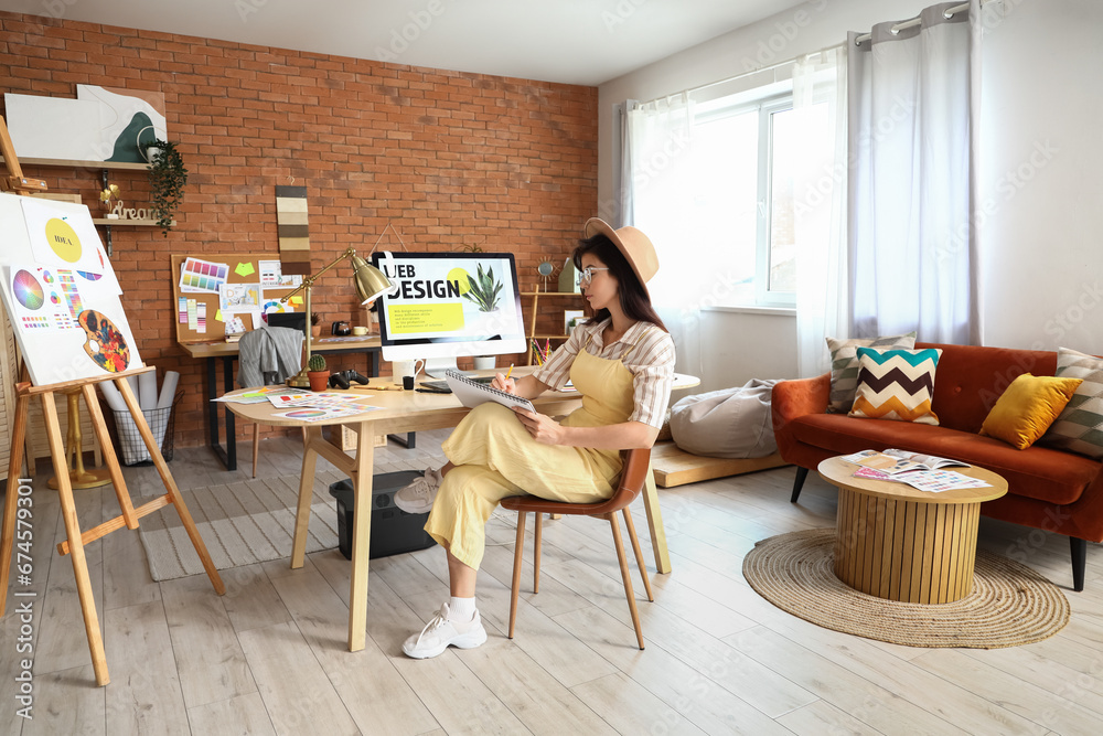 Female interior designer working at table in office