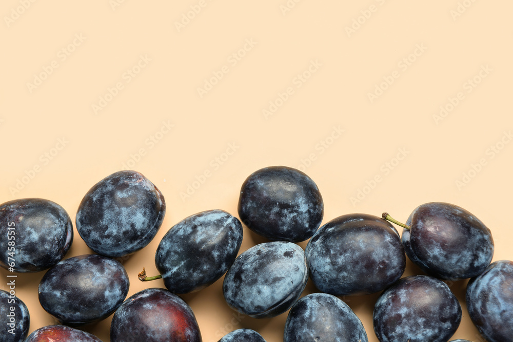 Many fresh plums on yellow background