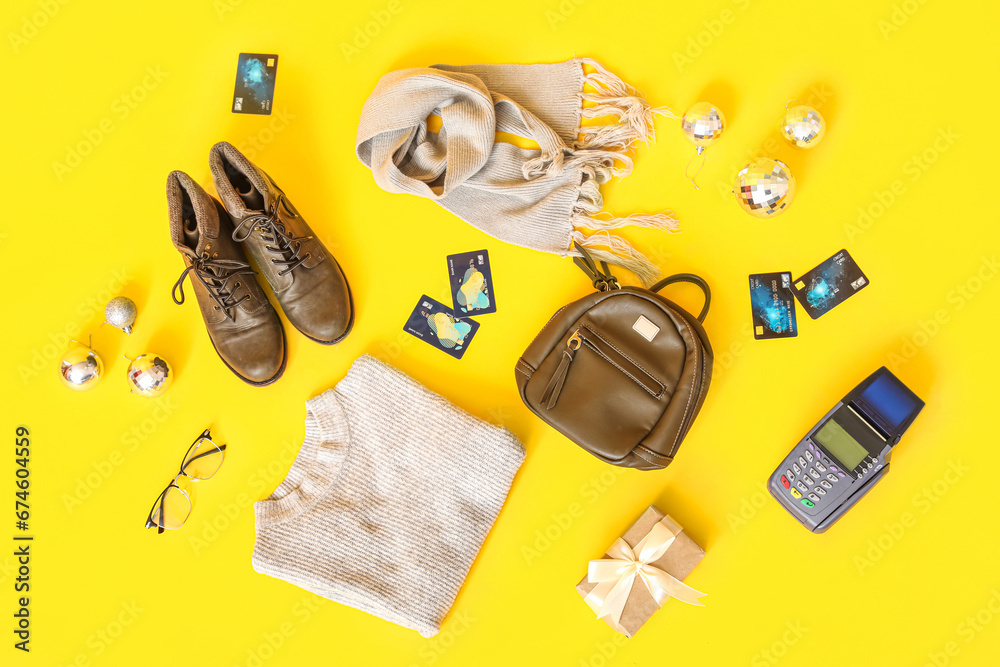 Composition with female clothes, credit cards and Christmas balls on yellow background