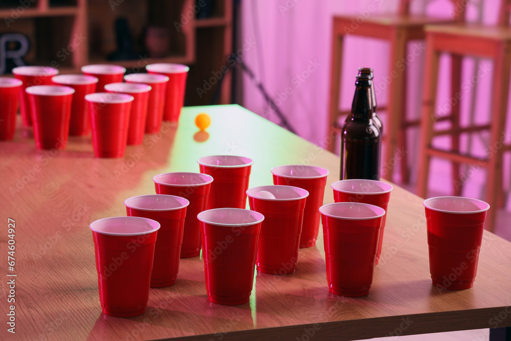 Cups for beer pong on table in room, closeup