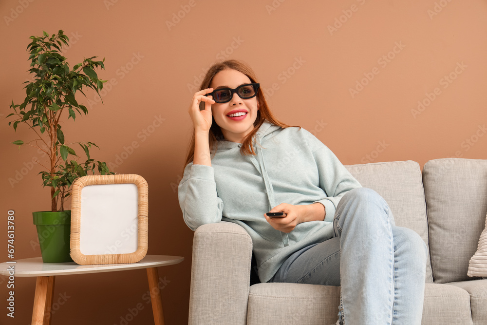 Pretty young woman with TV remote control watching movie in living room