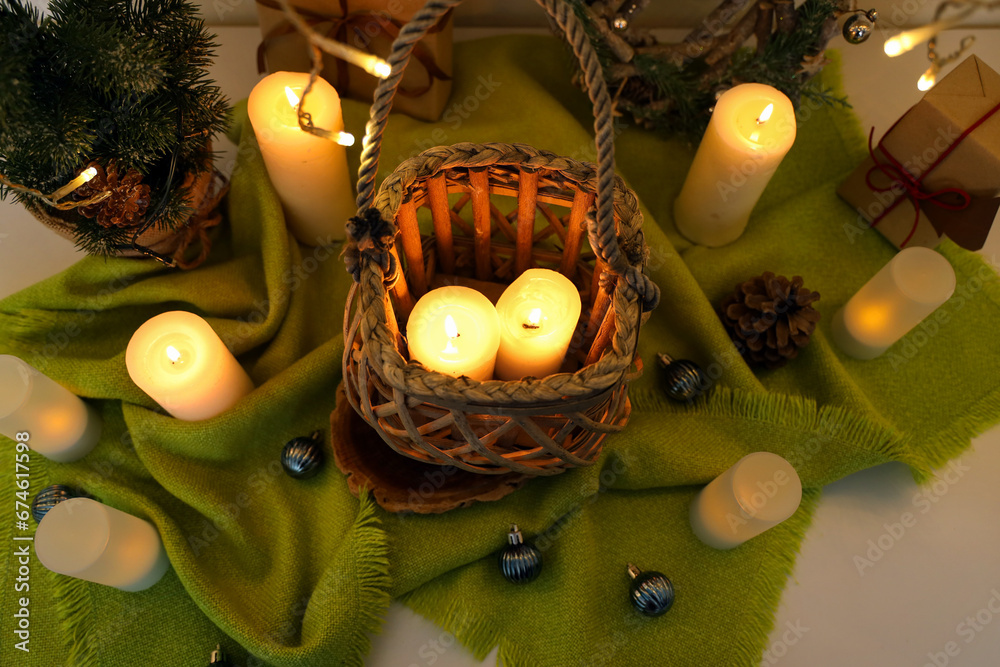 Burning candles with Christmas tree and balls on table, closeup