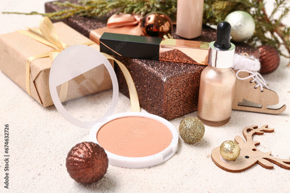 Christmas composition with makeup products, fir tree branch and gift boxes on light background, closeup