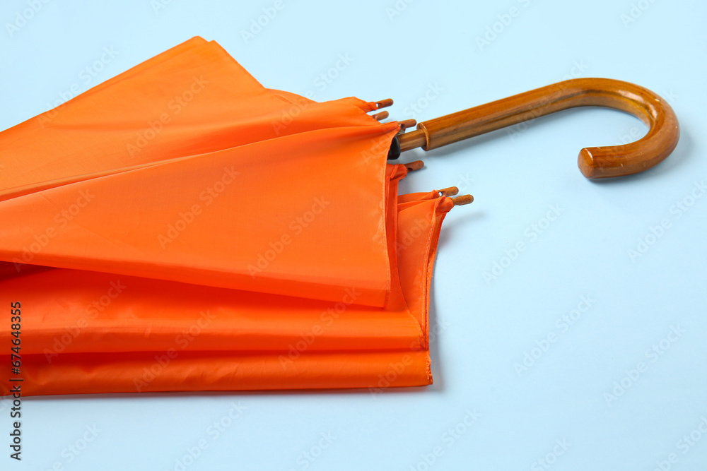 Orange stylish umbrella on blue background