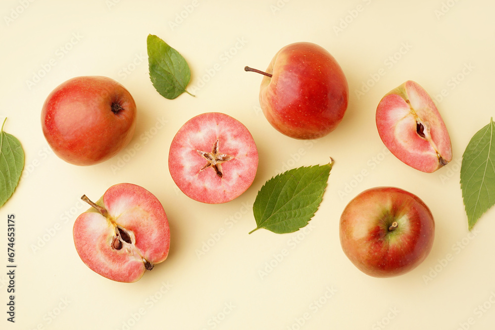 Sweet pink apples and leaves on yellow background