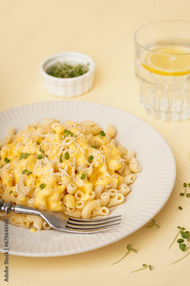 Plate of tasty Italian pasta with Cheddar cheese on yellow background, closeup