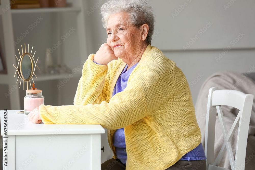 Thoughtful senior woman sitting at home