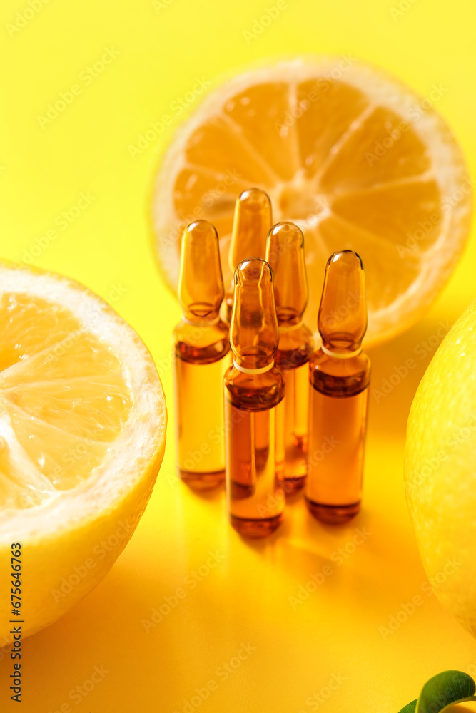 Ampoules with vitamin C and lemon on yellow background, closeup