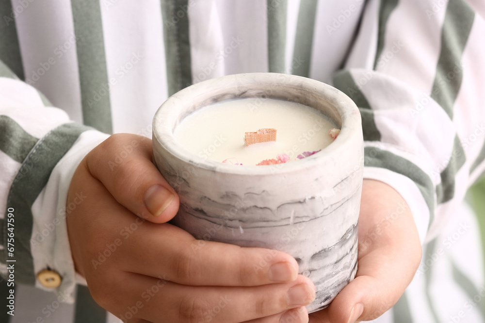 Woman holding candle with flowers, closeup