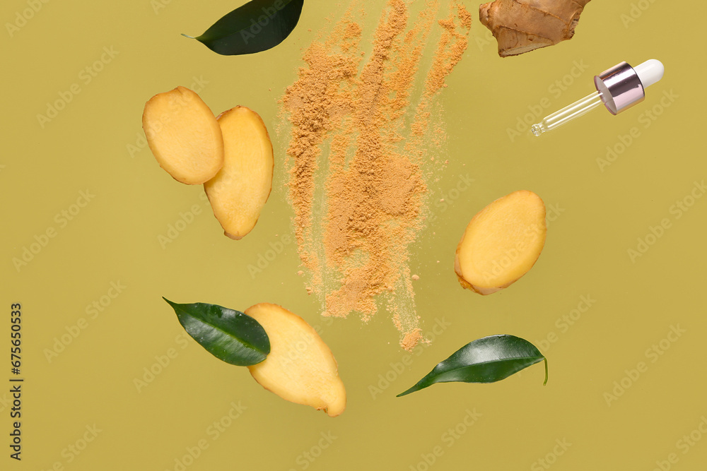 Flying slices of fresh ginger root with dried powder and cosmetic dropper on green background