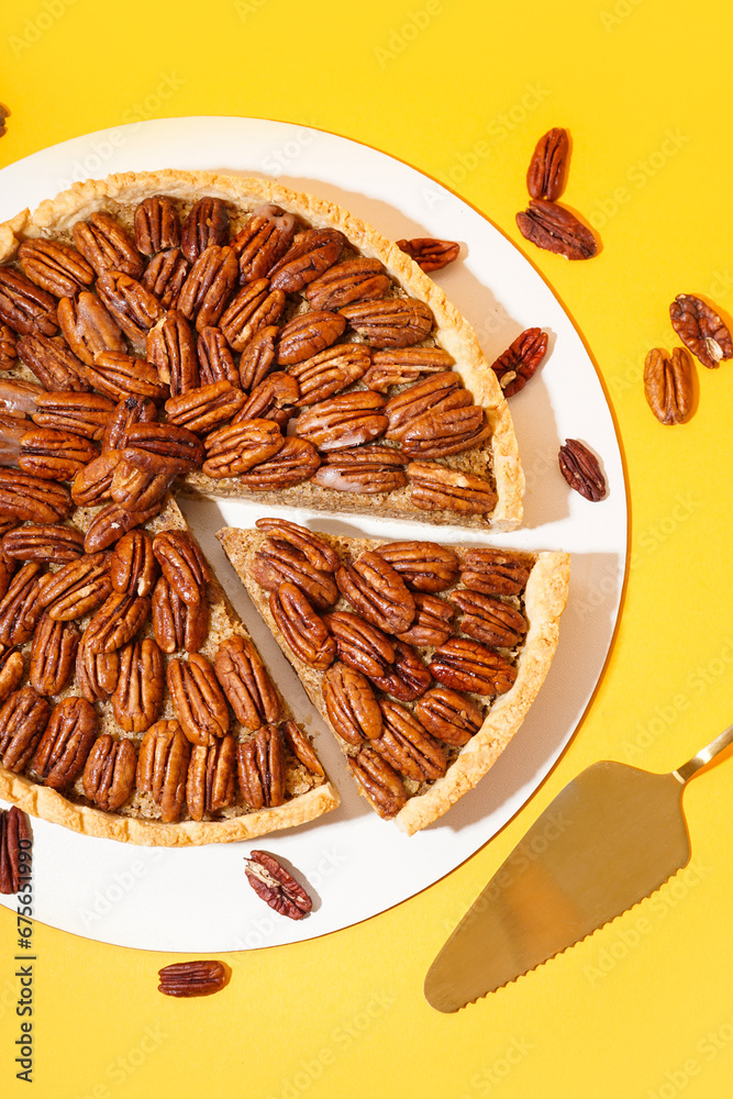 Tasty pecan pie on yellow background