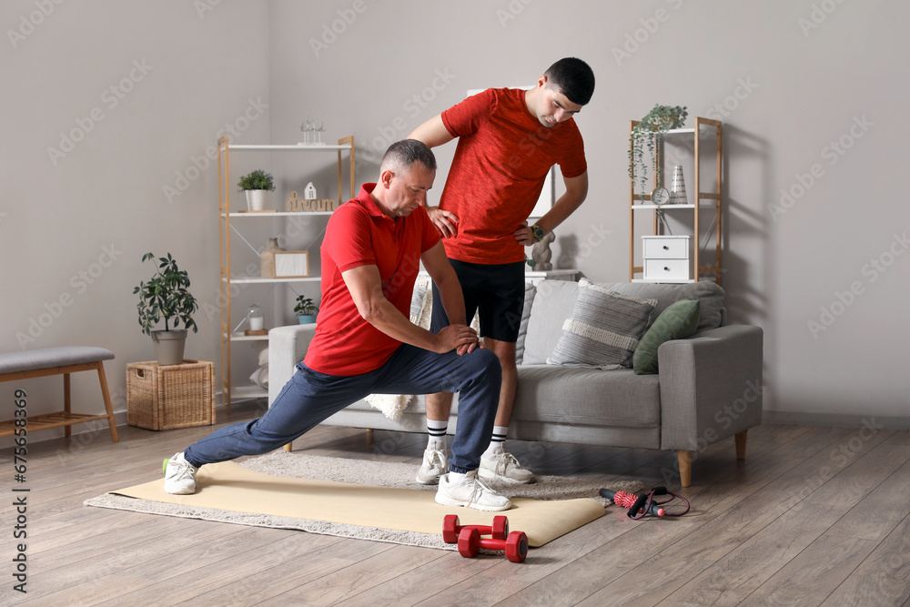 Mature man training with rehabilitation therapist at home