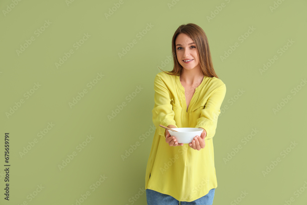 Young woman with chicken soup on green background