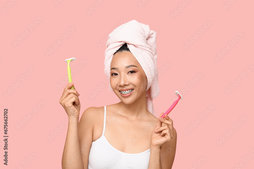 Young Asian woman with razors on pink background, closeup