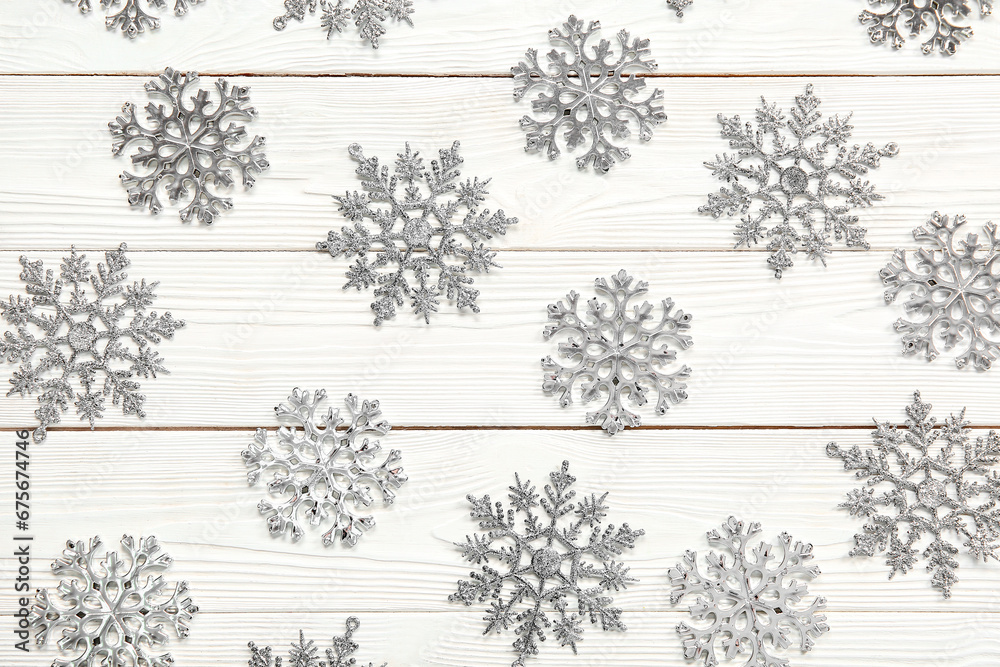 Many beautiful snowflakes on white wooden background