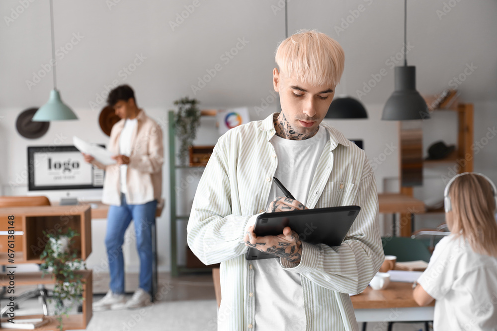 Male graphic designer working with tablet in office