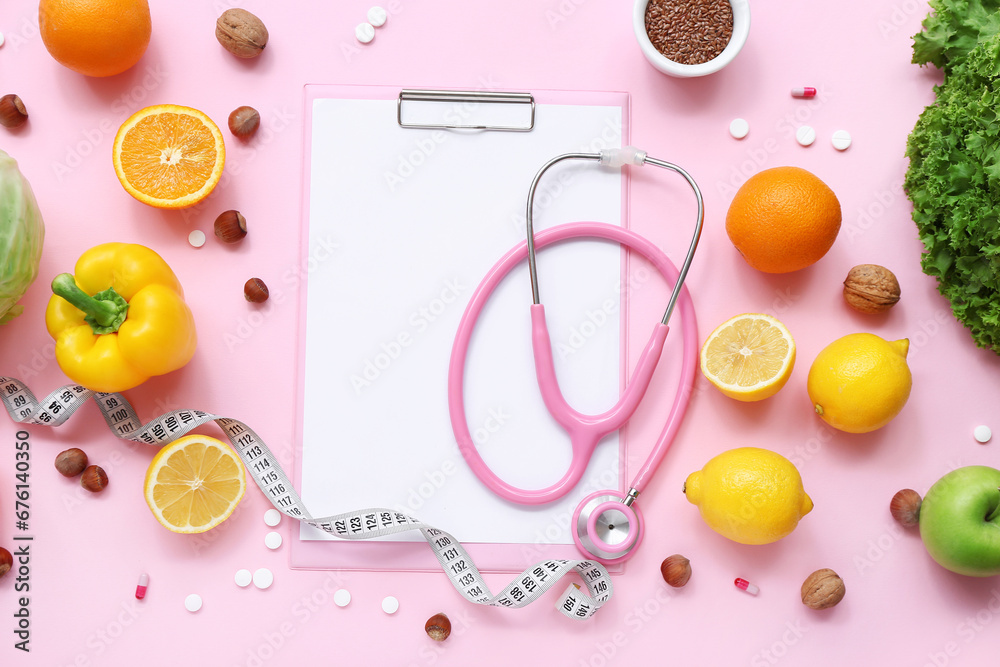 Composition with clipboard, stethoscope and healthy food on pink background