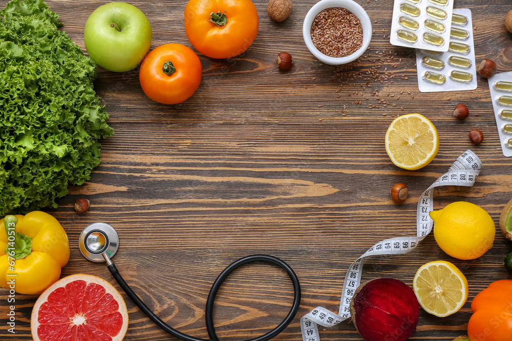 Frame made of different healthy products, pills and measuring tape on wooden background