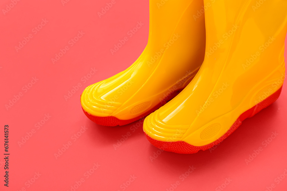 Yellow gumboots on red background