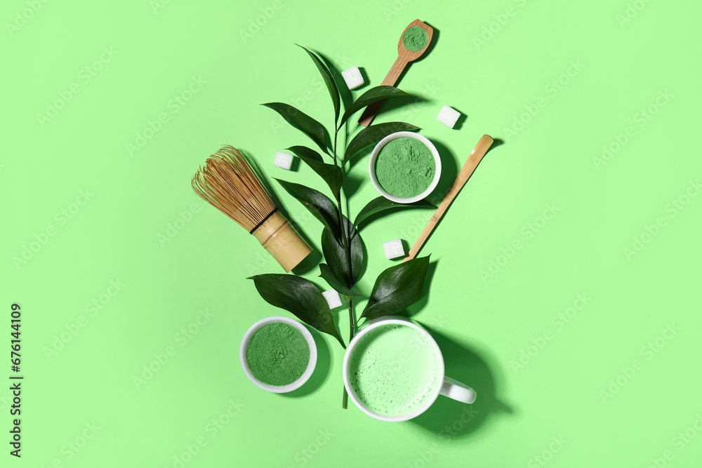 Composition with fresh matcha tea, powder, accessories and plant branch on green background