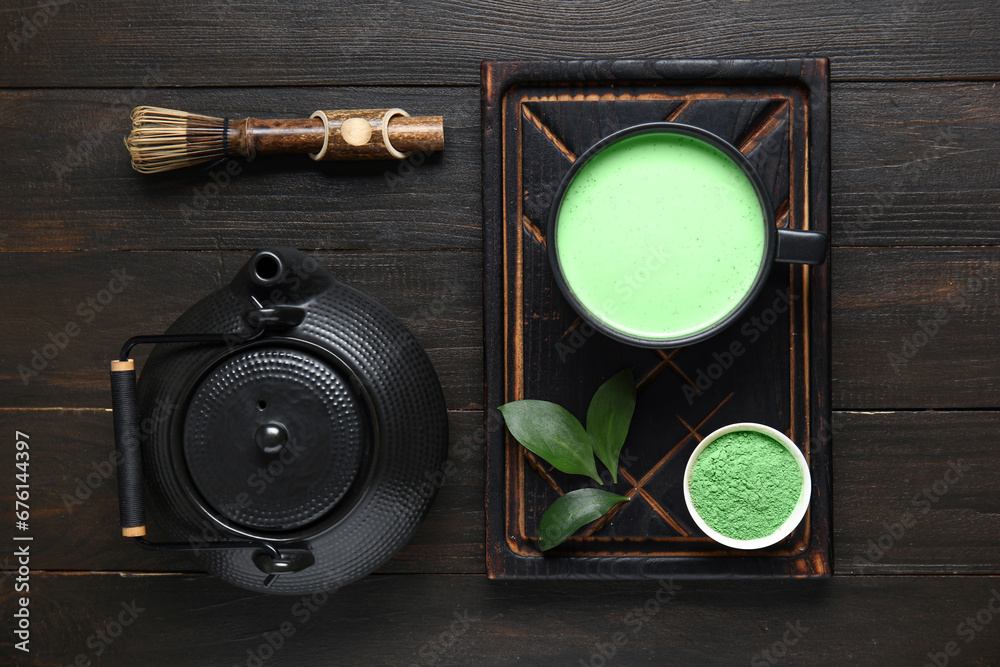 Composition with matcha tea, chasen and teapot on dark wooden background