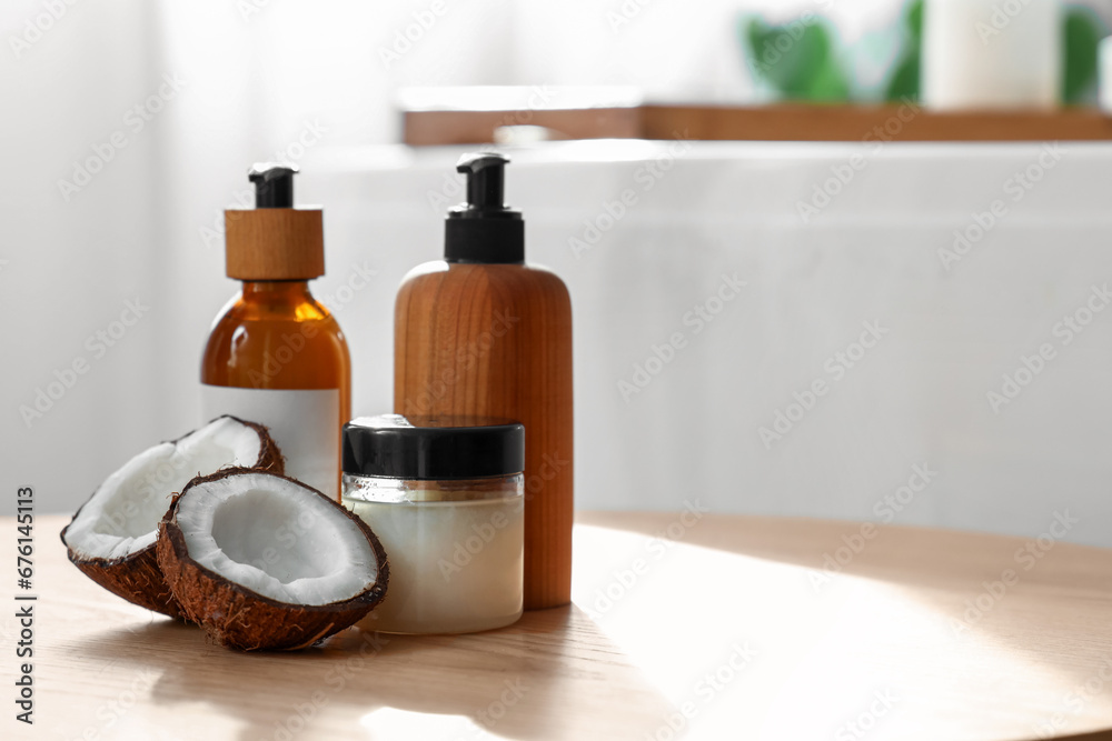 Coconut with cosmetic products on table in bathroom, closeup