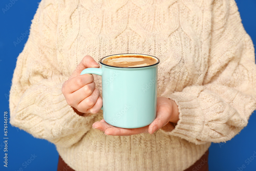 Woman with mug of coffee on blue background