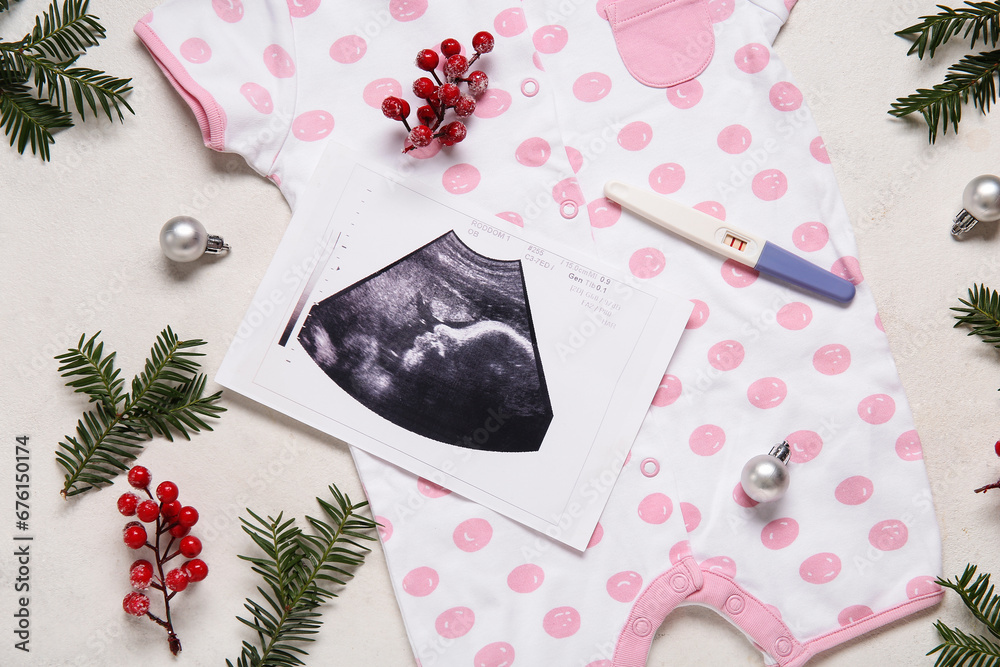 Composition with baby clothes, sonogram image and Christmas decorations on light background, closeup