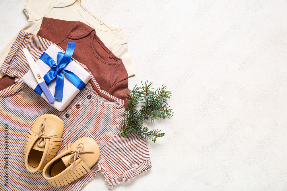 Composition with stylish baby clothes, pregnancy test and Christmas gift on light background