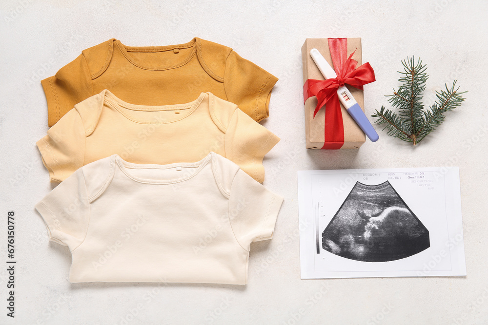 Composition with baby clothes, sonogram image, pregnancy test and Christmas gift on light background