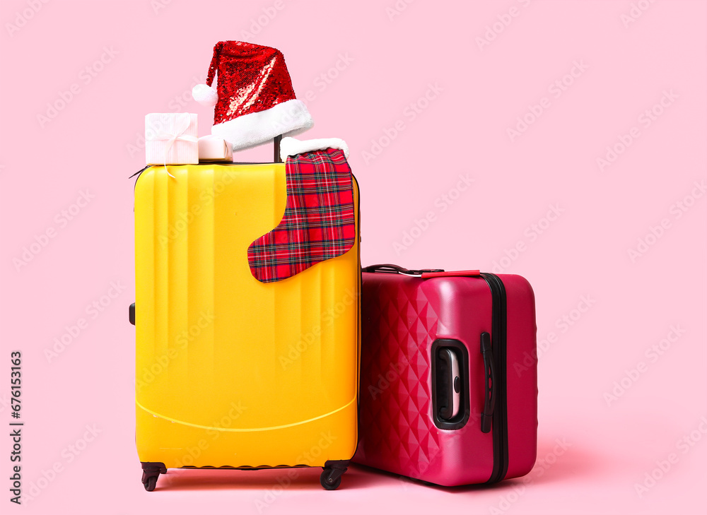 Suitcases, Christmas decor and gifts on color background