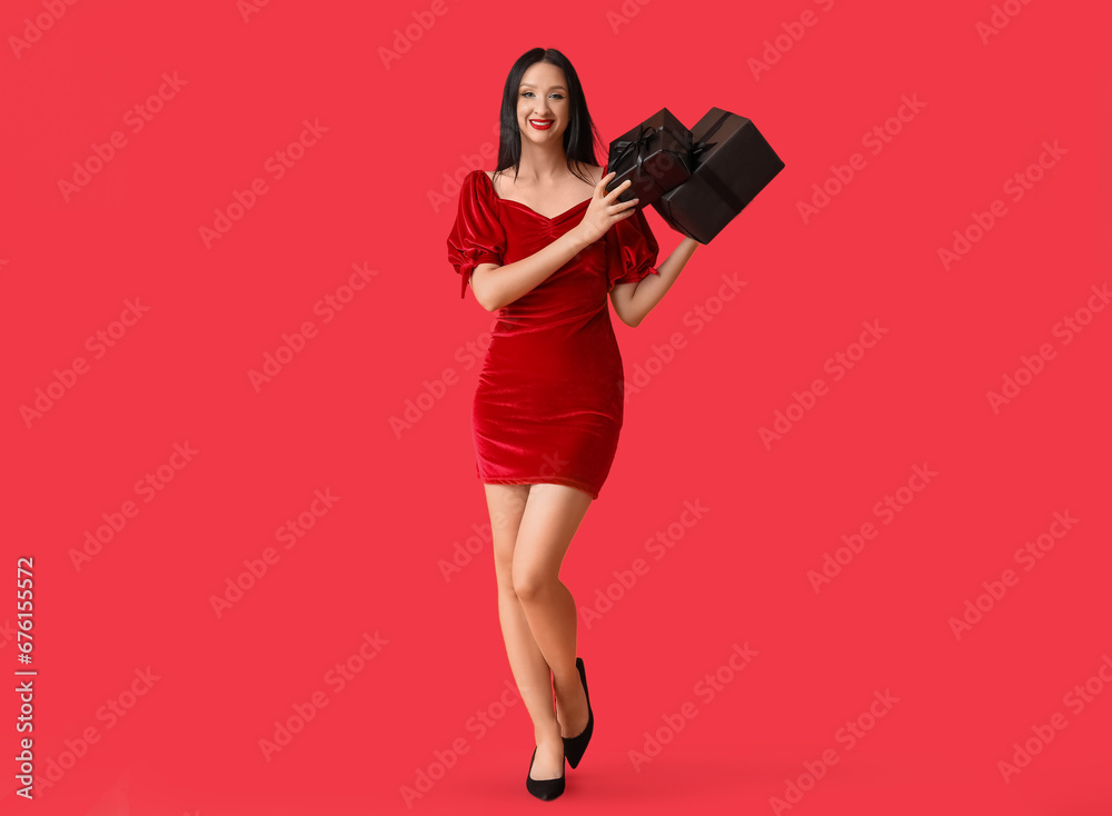 Beautiful stylish woman with gift boxes on red background. Black Friday Sale